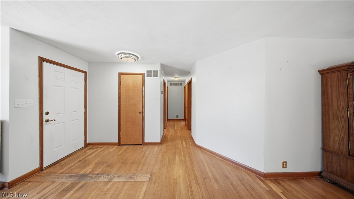 89 Dagg Road Parkersburg, WV 26101 - Photo 26 of 45 Entryway featuring a paneled white door with dark wood trim, wood-finish flooring, a flush-mount ceiling light, and a hallway extending into the interior