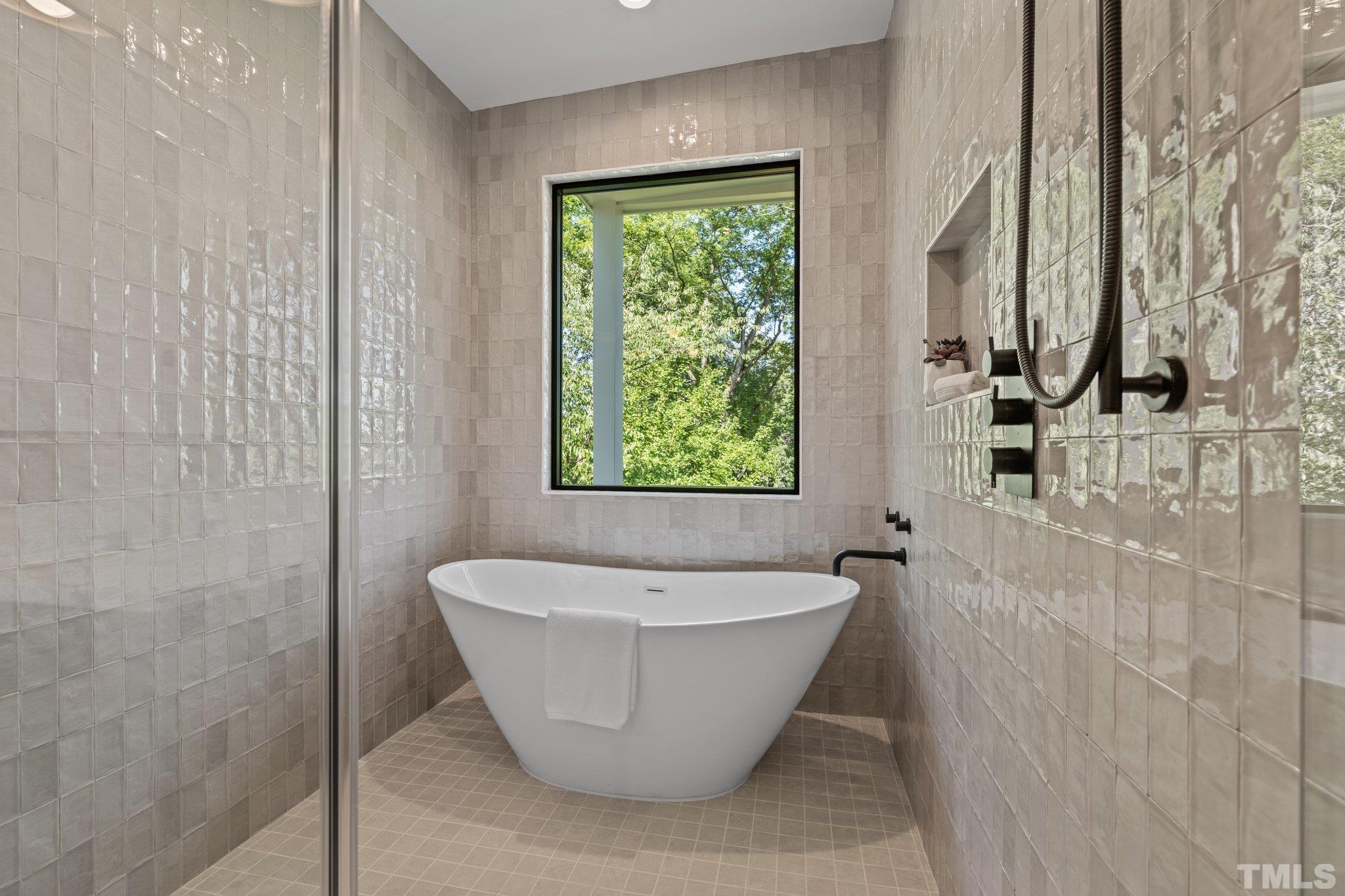 907 North State Street, Unit 101 Raleigh, NC 27604 - Photo 29 of 58 a white bath tub sitting in a bathroom next to a window