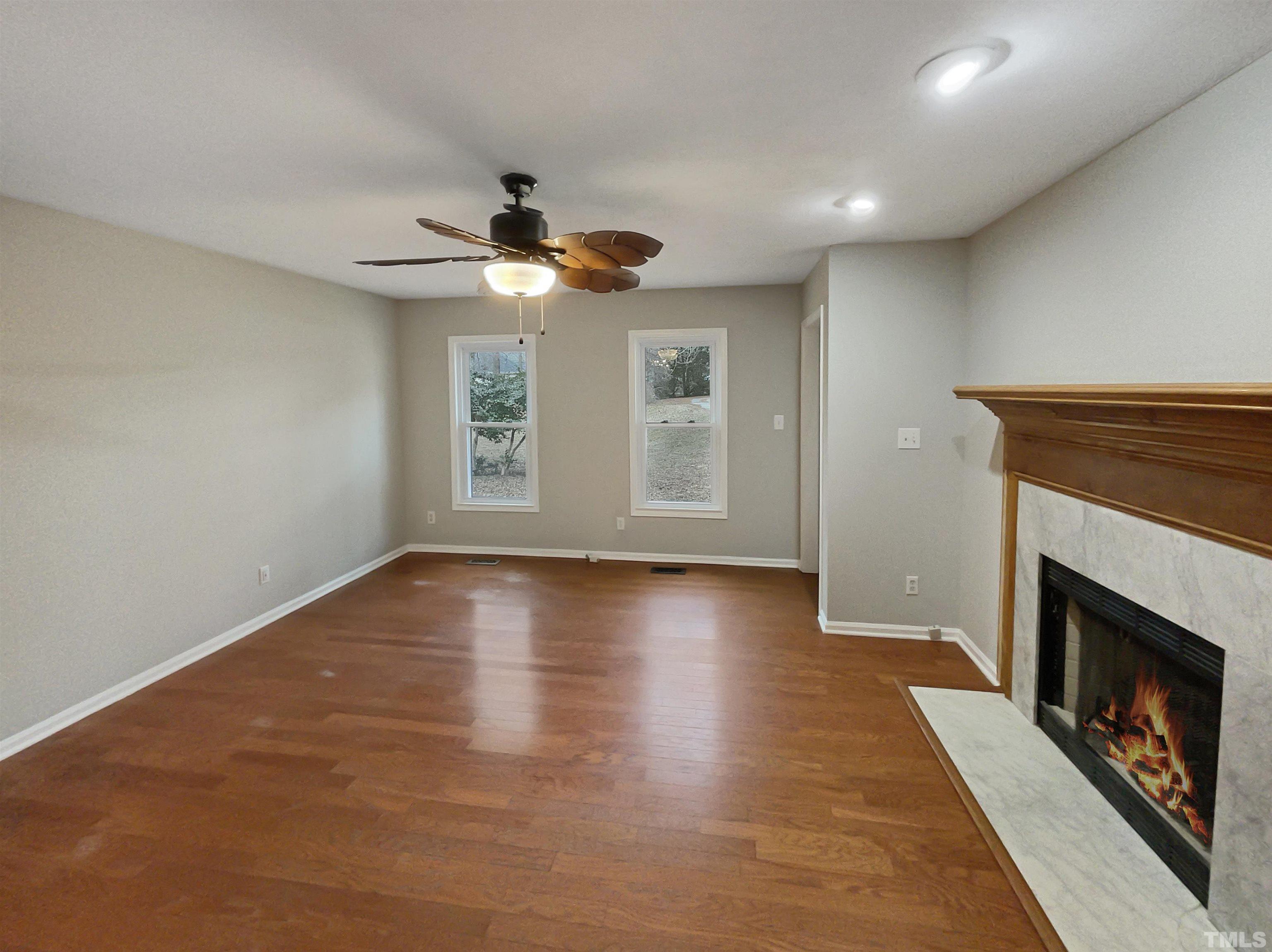 200 Lassiter Farm Road Raleigh, NC 27603 - Photo 3 of 19 an empty room with windows and fireplace