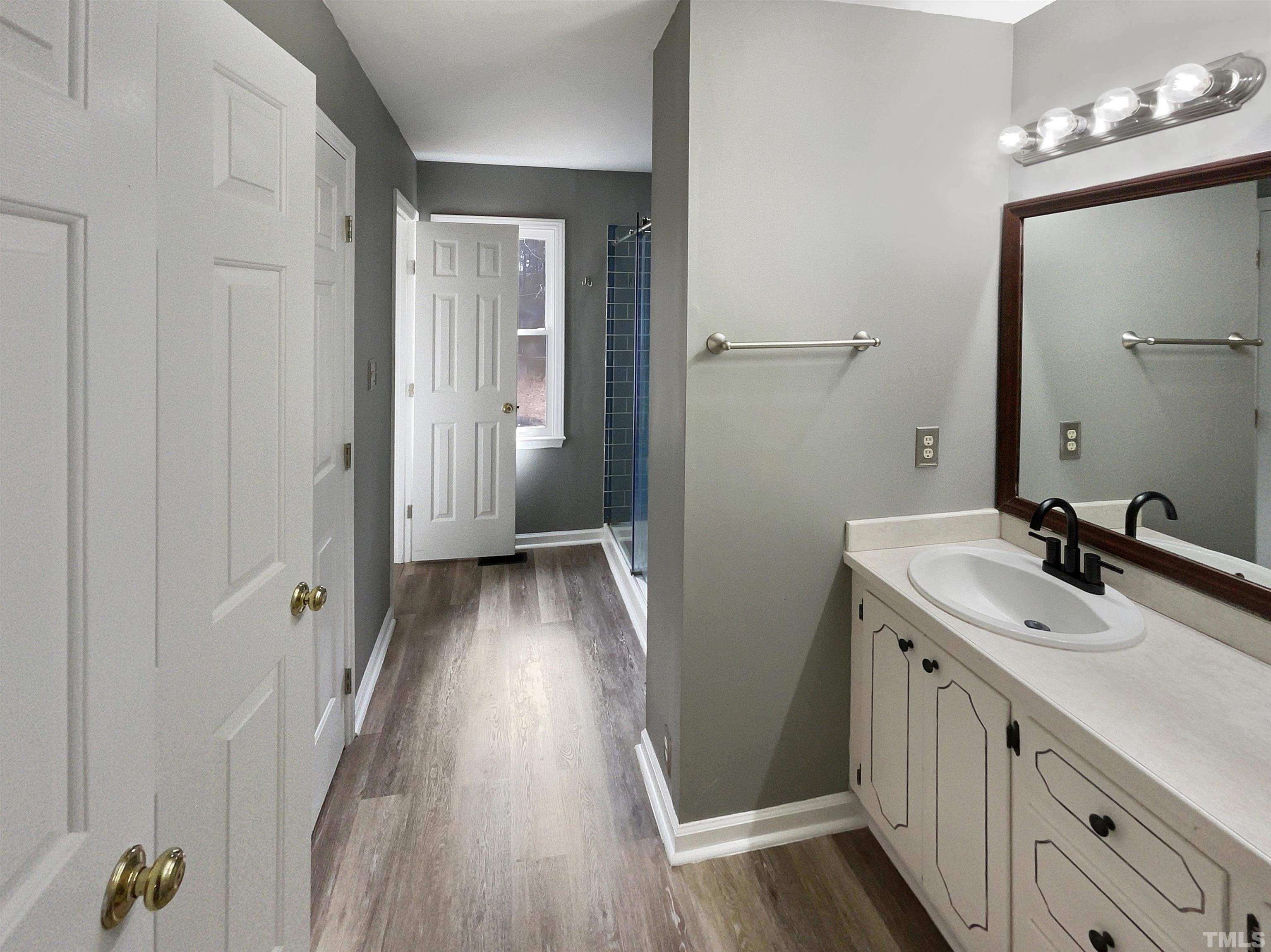 200 Lassiter Farm Road Raleigh, NC 27603 - Photo 8 of 19 a bathroom with a sink a mirror and a shower