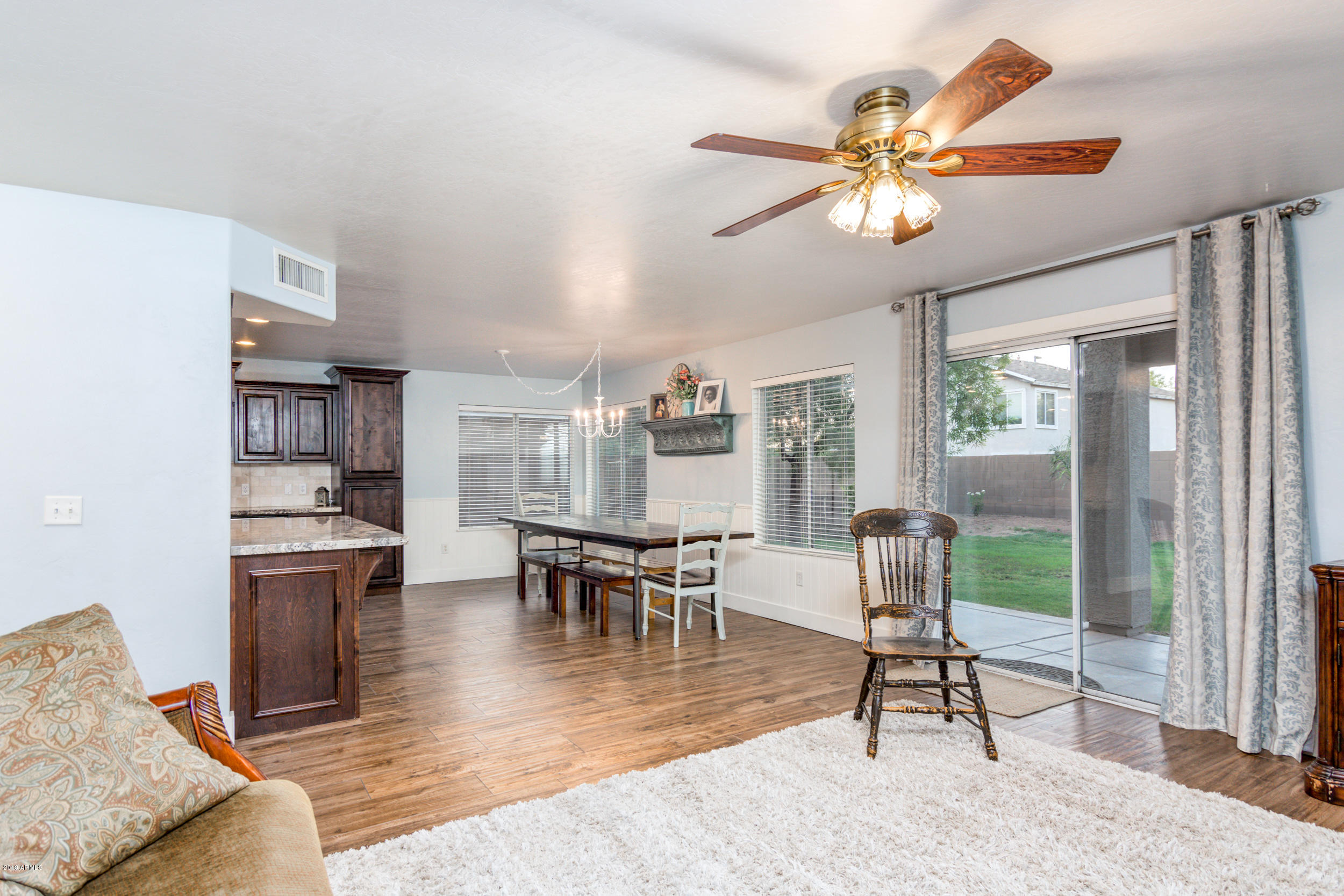 2644 East Del Rio Street Gilbert, AZ 85295 - Photo 13 of 42 a dining room with wooden floor a chandelier a glass table and chairs