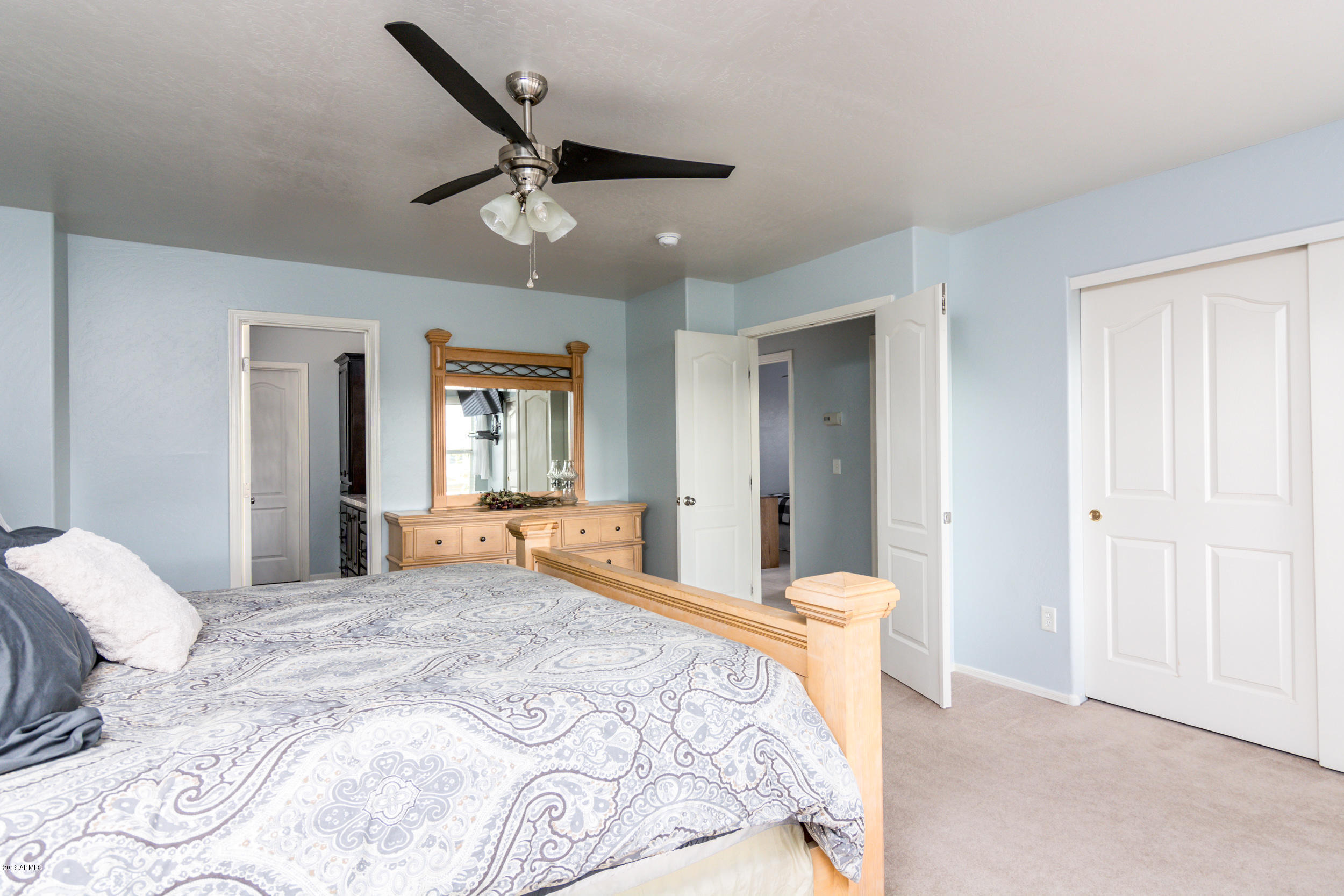 2644 East Del Rio Street Gilbert, AZ 85295 - Photo 19 of 42 a bedroom with a large bed and a chandelier