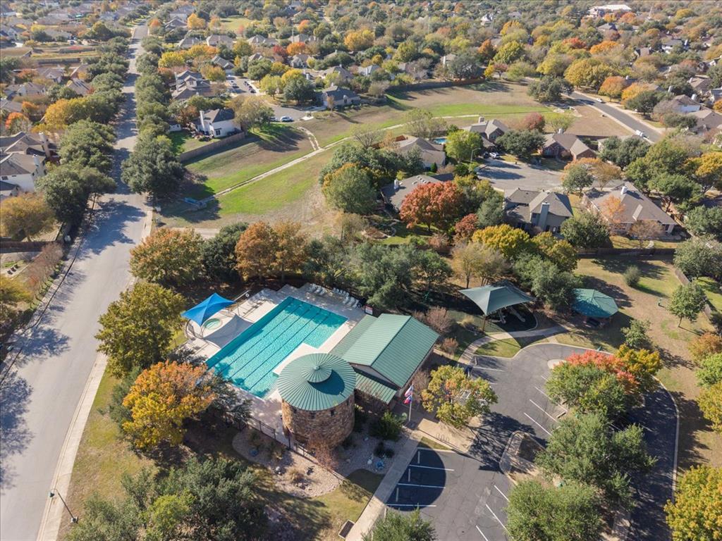 12212 Tawny Farms Road, Unit 142 Austin, TX 78748 - Photo 18 of 21 An aerial perspective reveals a vibrant community pool area surrounded by lush autumnal trees and residential homes.