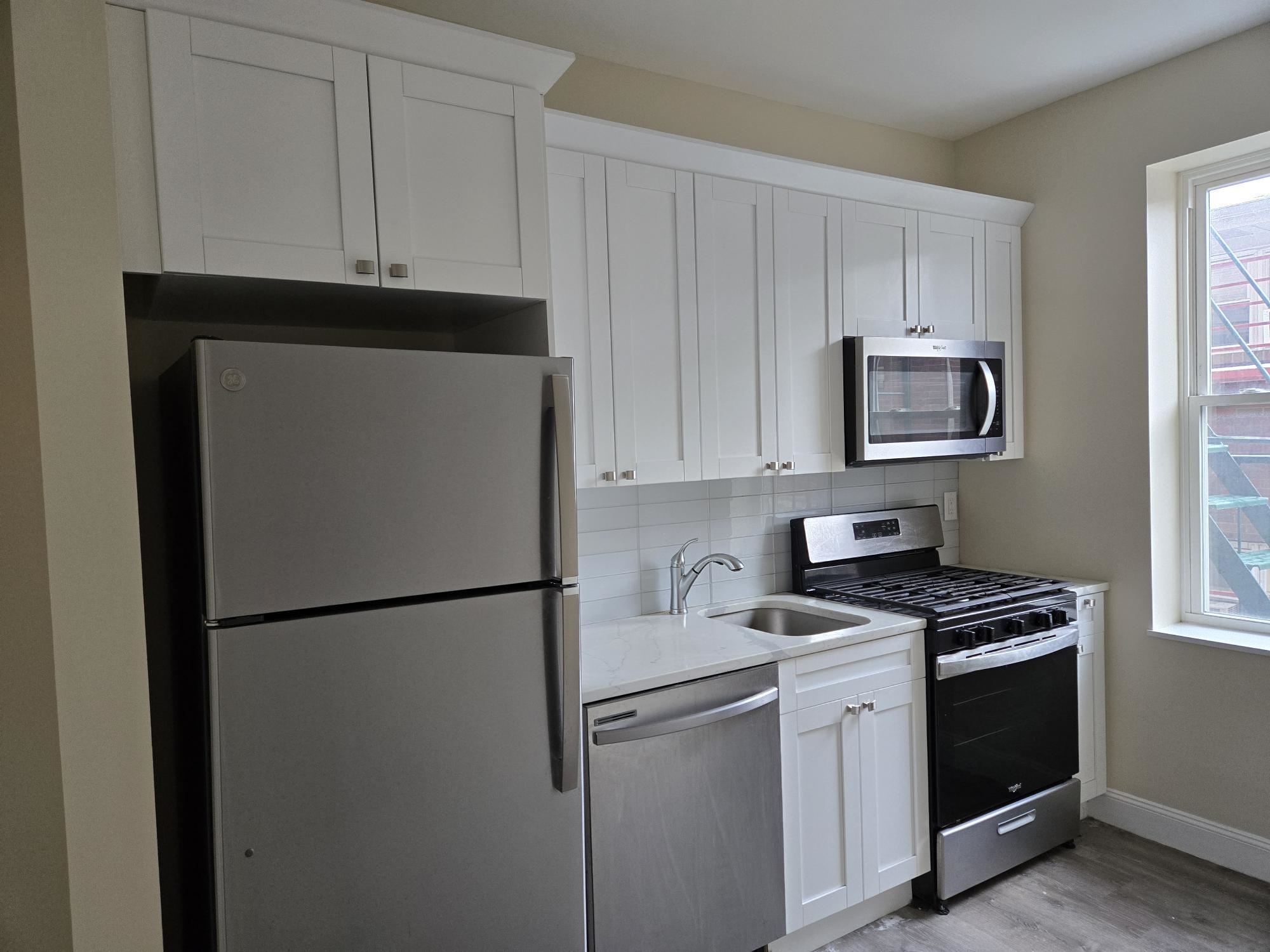 289 Day Avenue, Unit B2 Fairview, NJ 07022 - Photo 1 of 6 a kitchen with stainless steel appliances white cabinets and a refrigerator