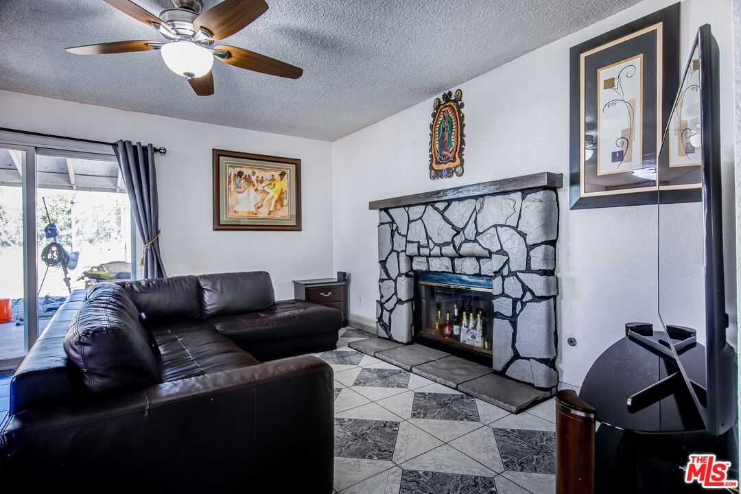 981 West Long Beach Drive Colton, CA 92324 - Photo 12 of 33 a living room with furniture a fireplace and a window