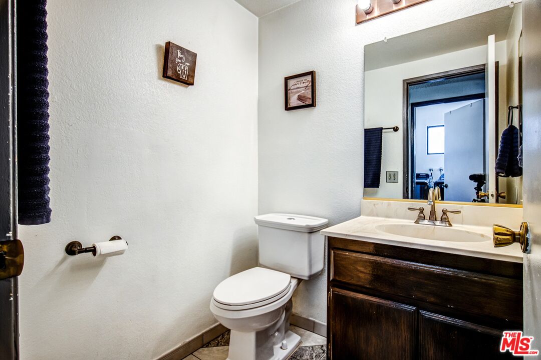 981 West Long Beach Drive Colton, CA 92324 - Photo 14 of 33 a bathroom with a sink toilet and mirror