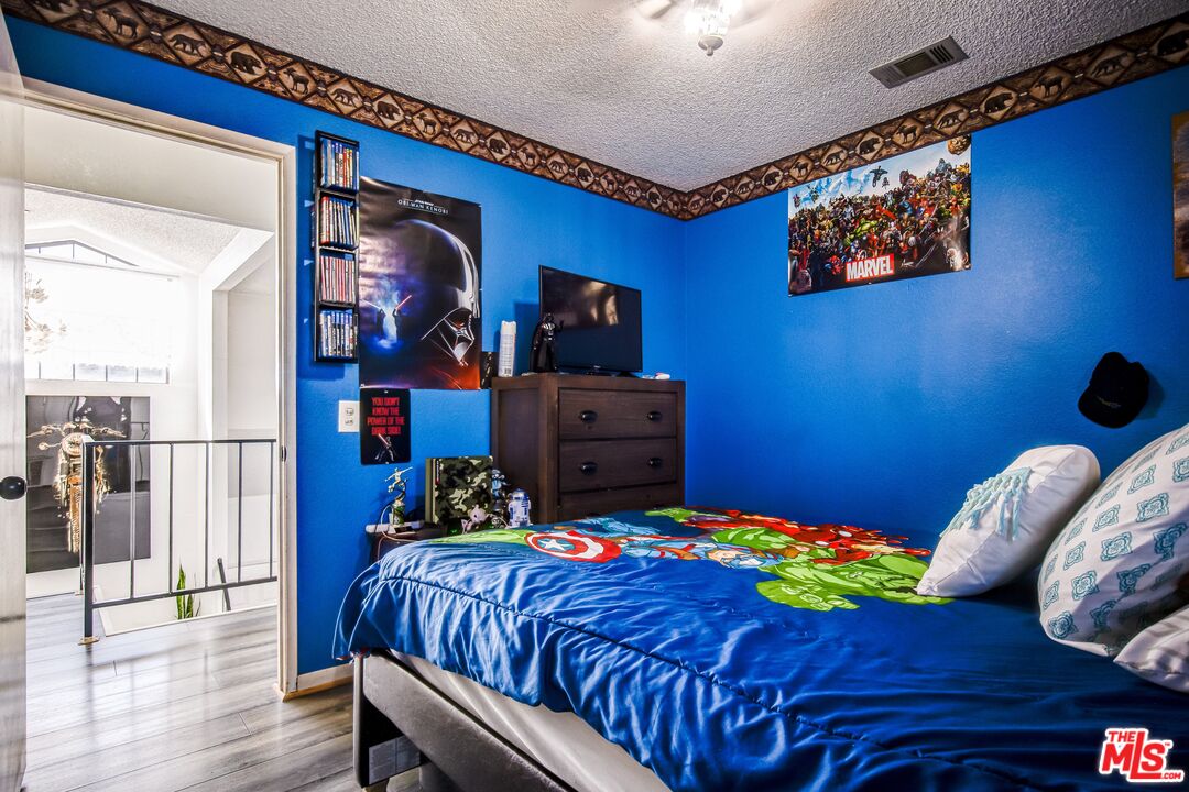 981 West Long Beach Drive Colton, CA 92324 - Photo 23 of 33 a bedroom with a bed and wooden floor