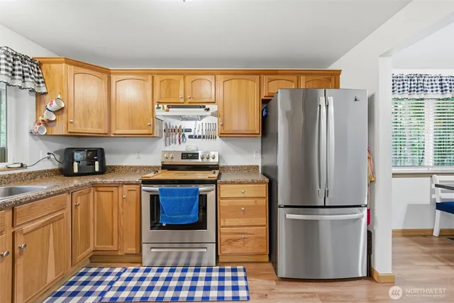 a kitchen with stainless steel appliances granite countertop a refrigerator and a stove