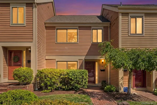 a front view of a house with plants