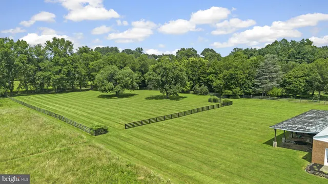 a view of a green field with wooden fence