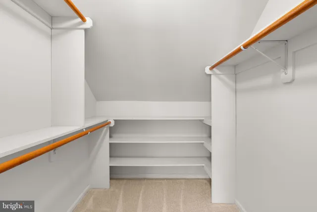 a view of walk in closet with empty racks