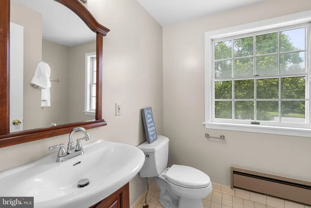 a bathroom with a sink a toilet and a window
