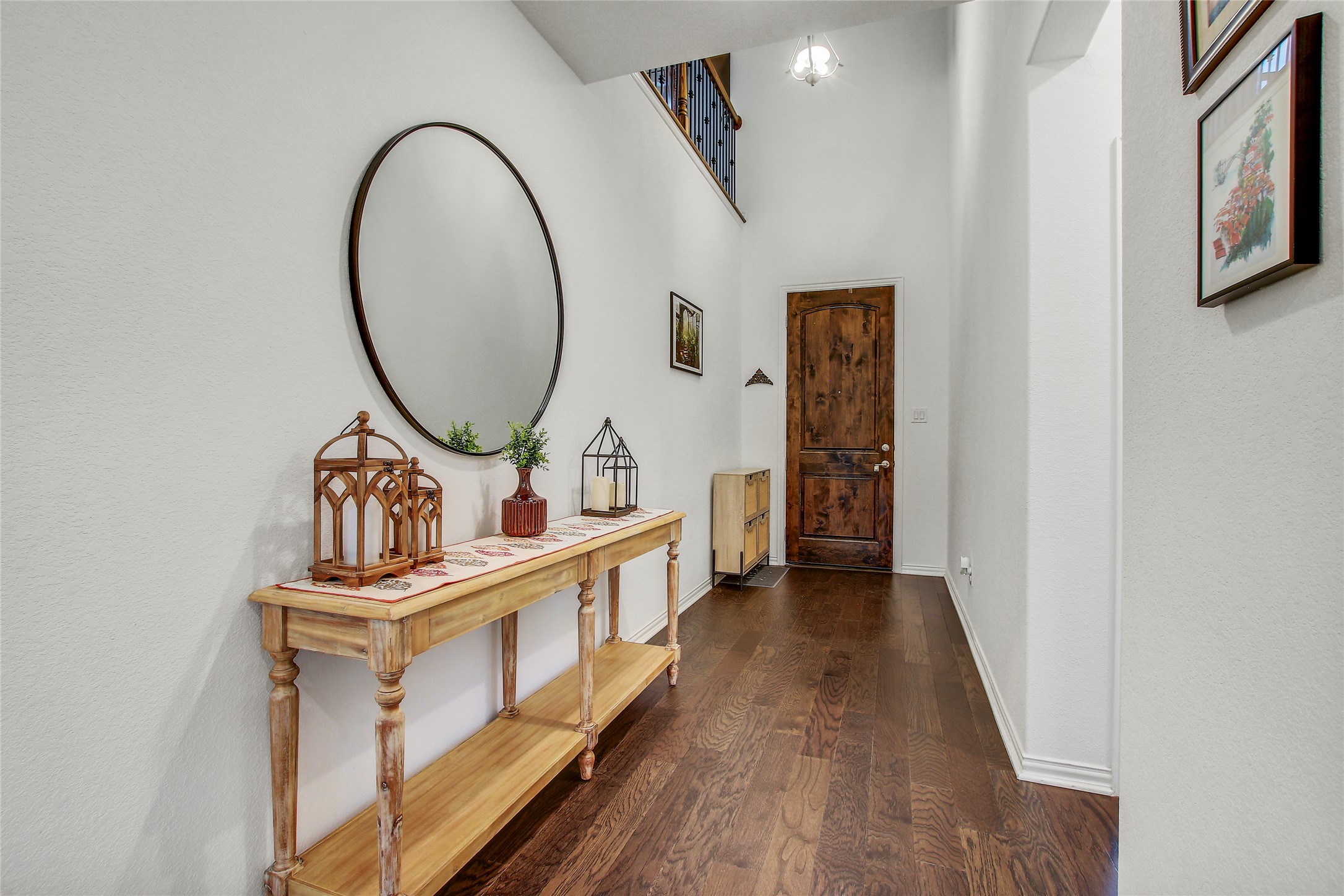 104 Millbend Road Georgetown, TX 78633 - Photo 3 of 40 A spacious entry hallway features dark wood flooring, tall ceilings, and a striking wooden entry door.