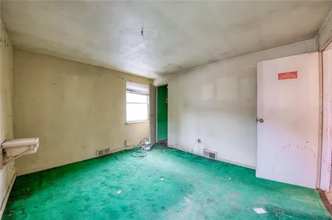 a view of an empty room with window and stairs