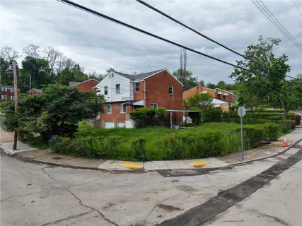 a front view of a house with a yard and potted plants