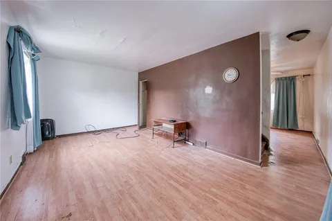 an empty room with wooden floor and a projector