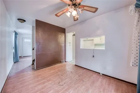 an empty room with wooden floor chandelier fan and closet area