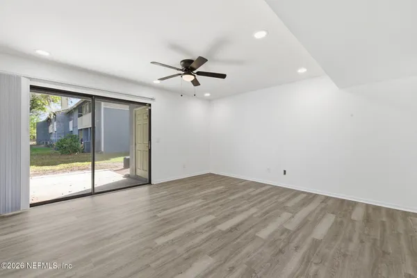 an empty room with wooden floor and windows