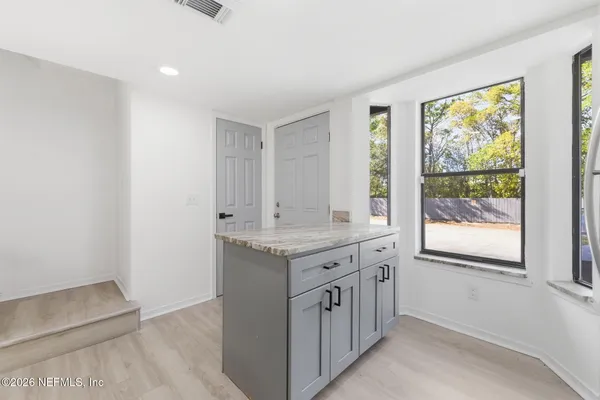 a kitchen with granite countertop a refrigerator stove and microwave