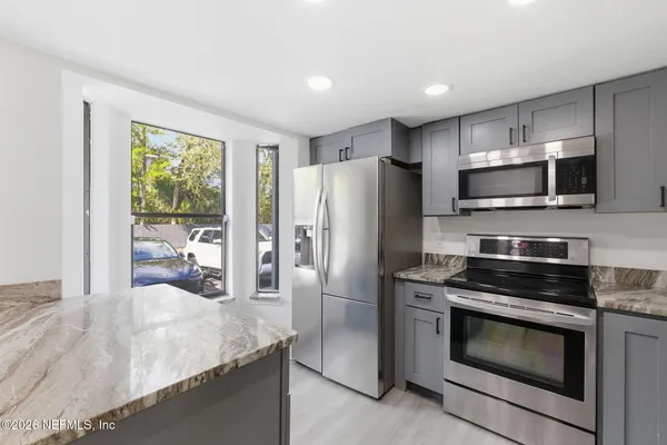 a kitchen with stainless steel appliances granite countertop a sink stove and refrigerator
