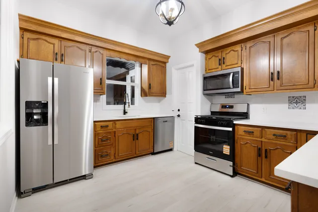 a kitchen with stainless steel appliances granite countertop a refrigerator stove and sink
