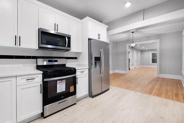 a kitchen with stainless steel appliances granite countertop a stove a refrigerator and a microwave