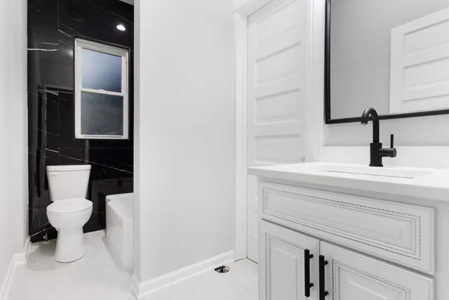 a bathroom with a toilet sink and a mirror