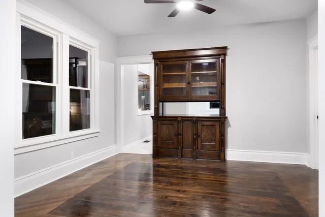 an empty room with wooden floor and cabinet