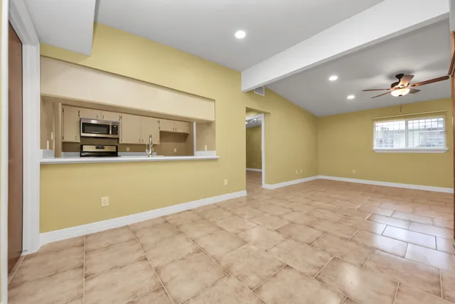 a view of a livingroom with wooden floor and kitchen space