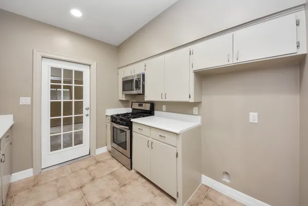 a kitchen with a stove top oven and cabinets