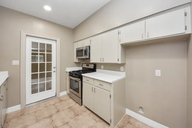 a kitchen with a stove top oven and cabinets