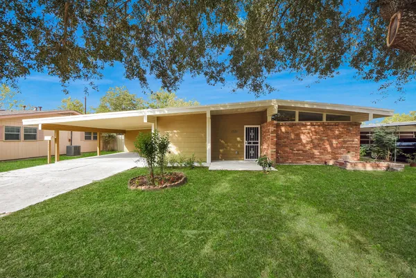 a front view of a house with a garden and yard