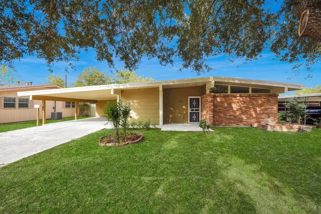 a front view of a house with a garden and yard