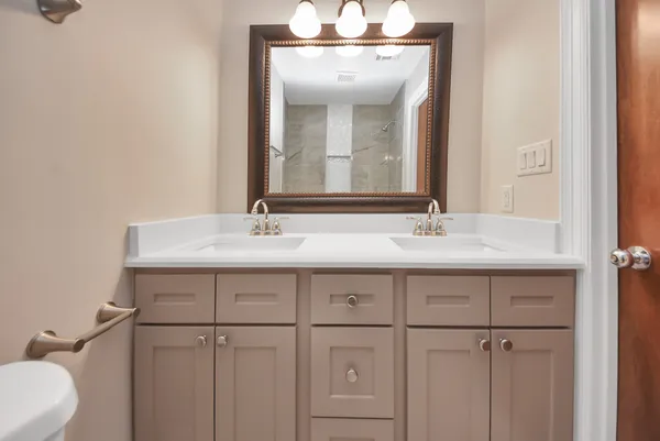 a bathroom with a double vanity sink and a mirror