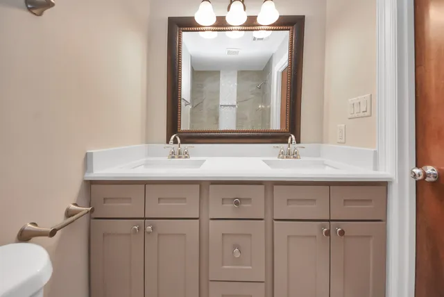 a bathroom with a double vanity sink and a mirror