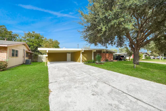 a front view of a house with a yard and trees