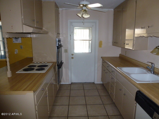 3032 West Bloomfield Road Phoenix, AZ 85029 - Photo 28 of 32 a kitchen with a sink stove and cabinets