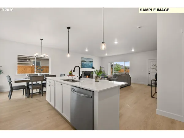 a kitchen with stainless steel appliances a sink a stove a refrigerator cabinets and wooden floor