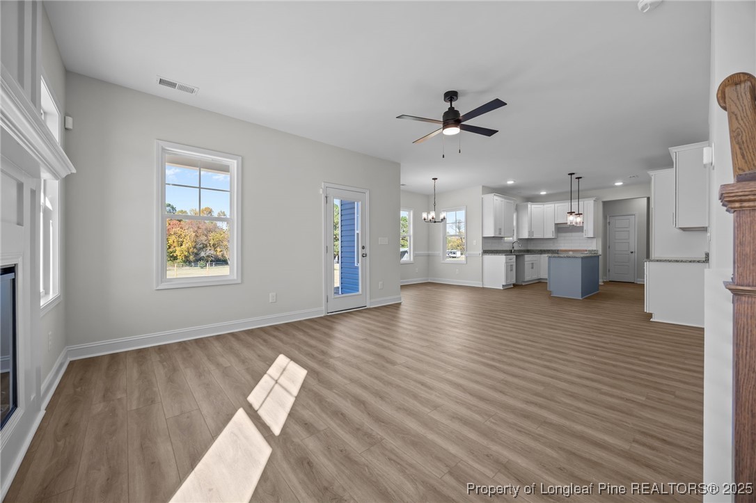 3202 Cameron Hill Road Cameron, NC 28326 - Photo 13 of 45 a view of an empty room and kitchen with wooden floor and a window