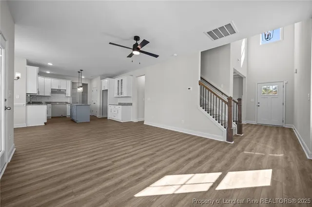 a view of empty room with wooden floor and fireplace