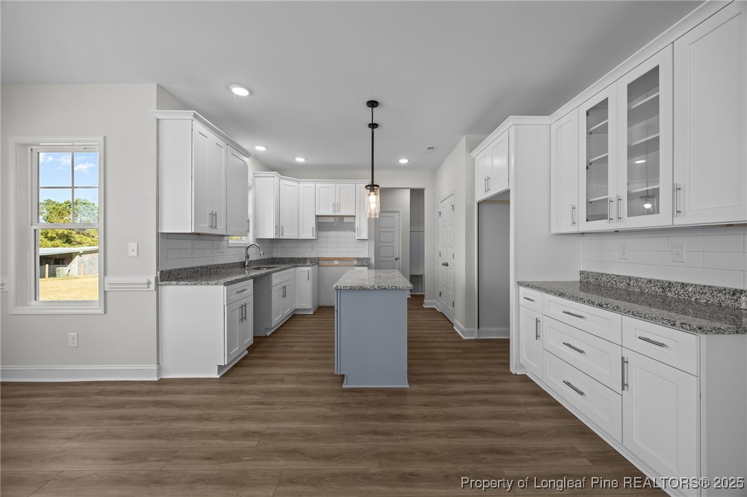 3202 Cameron Hill Road Cameron, NC 28326 - Photo 21 of 45 a white kitchen with granite countertop a stove top oven a sink dishwasher a refrigerator and white cabinets with wooden floor