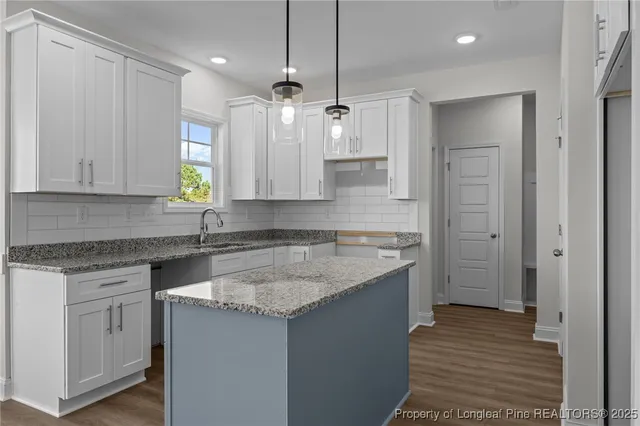 a kitchen with granite countertop a sink stainless steel appliances and cabinets