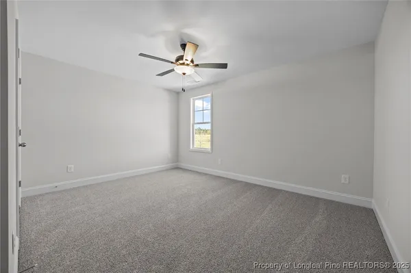 an empty room with closet and fan