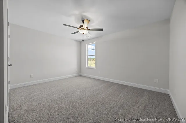 an empty room with closet and fan
