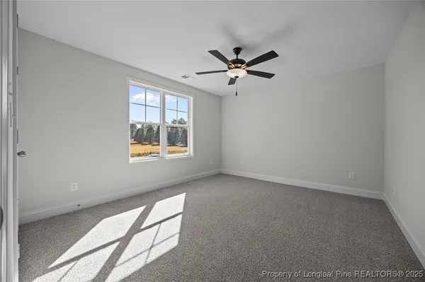 a view of empty room with ceiling fan