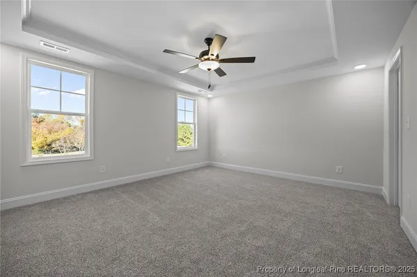 an empty room with closet and a ceiling fan
