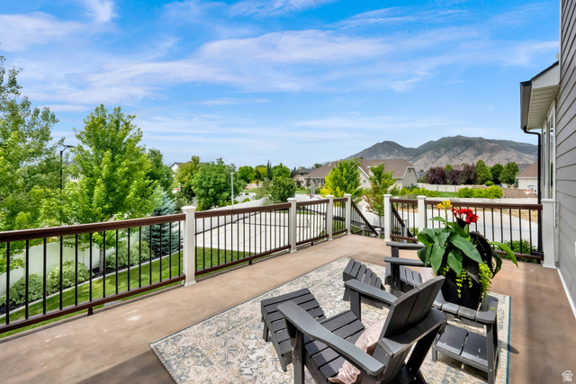 1132 South 1300th Street West Mapleton, UT 84664 - Photo 40 of 52 Spacious outdoor deck with a concrete surface, bordered by a black wrought iron railing and white posts