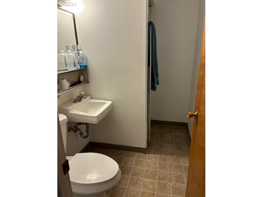 219-221 Northwest 13th Street Pendleton, OR 97801 - Photo 15 of 16 a bathroom with a sink a toilet and mirror