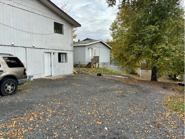 219-221 Northwest 13th Street Pendleton, OR 97801 - Photo 4 of 16 a view of a house with large trees and wooden fence