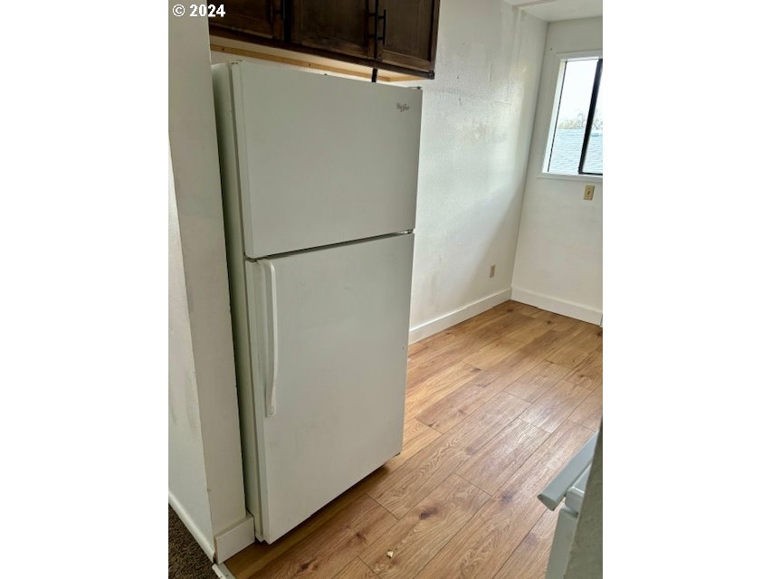 219-221 Northwest 13th Street Pendleton, OR 97801 - Photo 8 of 16 a view of a refrigerator in kitchen and an empty room